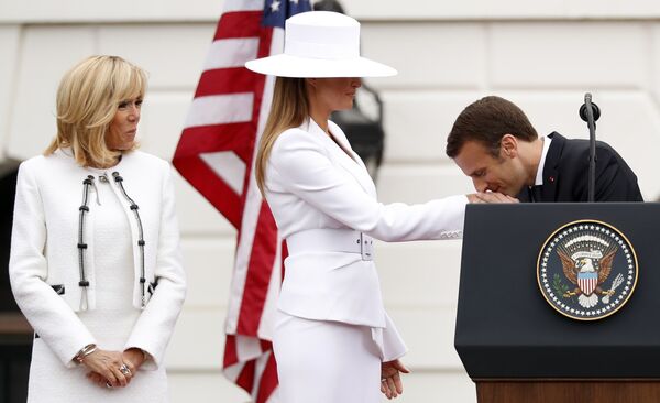 Президент Франции Эммануэль Макрон целует руку первой леди США Меланье Трамп во время во время приветственной церемонии в Белом доме в Вашингтоне, США. 24 апреля 2018 года
