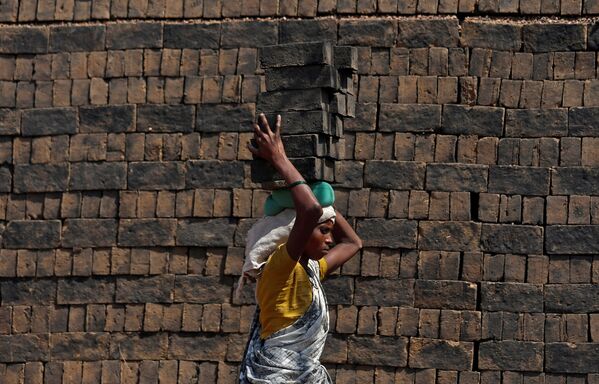 Женщина несет кирпичи на голове в Мумбаи