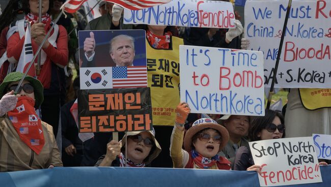 Митингующие активисты выступают против сближения с КНДР рядом с демилитаризованной зоной. 27 апреля 2018