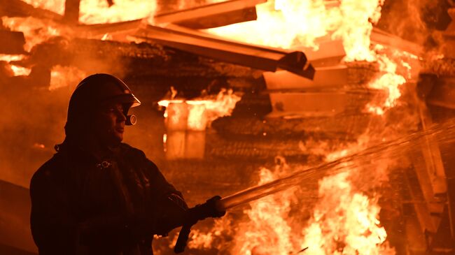 Сотрудник МЧС во время тушения пожара. Архивное фото