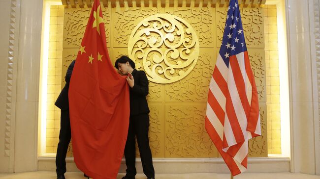 Служащие устанавливают флаг Китая перед встречей министра транспорта Китая Ли Сяопэна и министра транспорта США Элейн Лан Чао