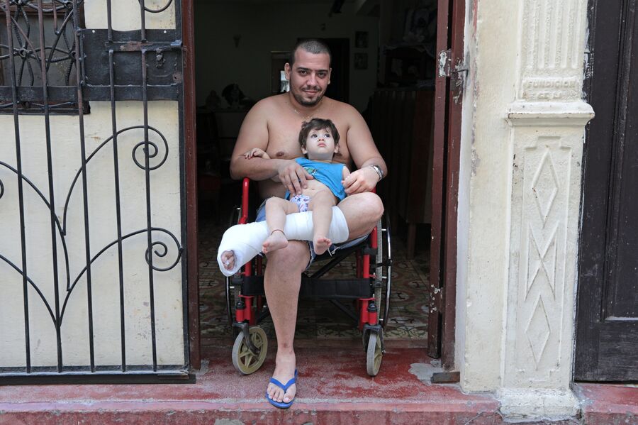 Кубинец с ребенком на улице в районе Старая Гавана