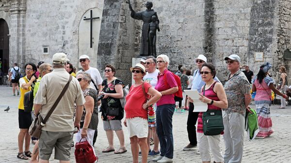 Иностранные туристы осматривают достопримечательности в районе Старая Гавана