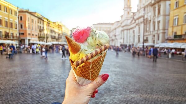 Человек держит мороженое на фоне Пьяцца Навона в Риме 