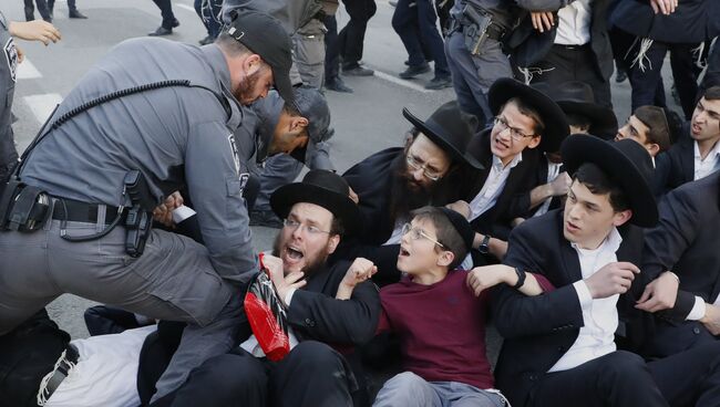 Сотрудники израильской службы безопасности пытаются разогнать ультраортодоксальных евреев во время демонстрации против воинского призыва в городе Бней-Брак, Израиль