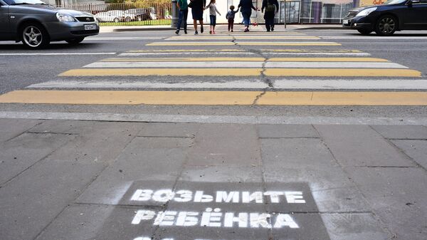 Предупреждающая надпись для пешеходов, нанесенная на асфальте перед переходом