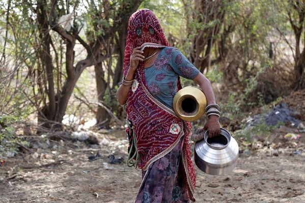 Женщина набирает питьевую воду из придорожной колонки на окраине Аджмера, в индийском штате Раджастхан