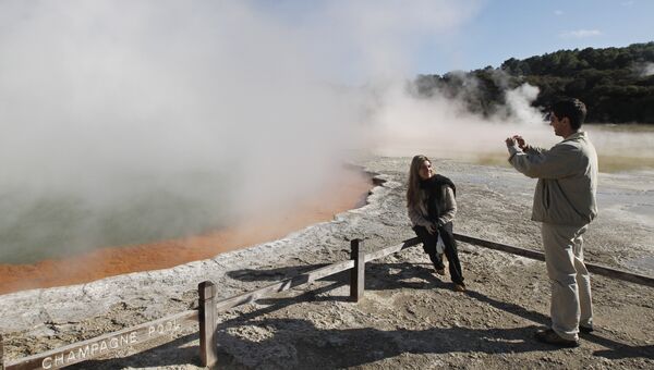Туристы фотографируют возле кратера в геотермальный парке Уаи-О-Тапу Новой Зеландии. 2011 год