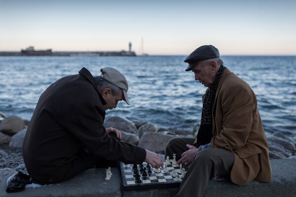 Мужчины играют в шахматы на набережной в Ялте