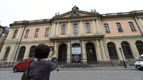 Женщина фотографирует здание Шведской академии в Стокгольме
