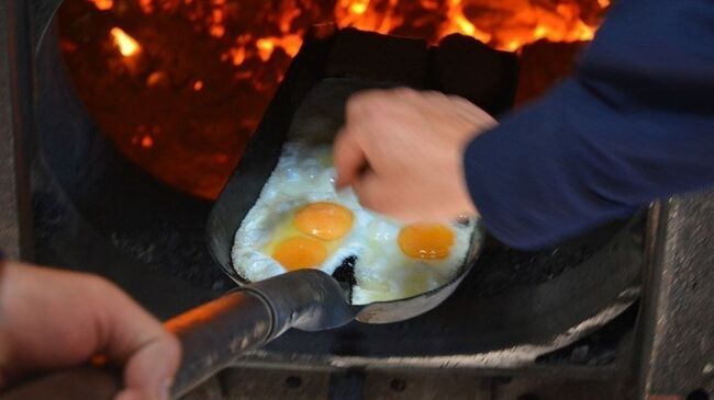 Приготовление яичницы на лопате в топке паровоза ретропоезда Воинский эшелон на железнодорожном вокзале Саратов-1. 4 мая 2018