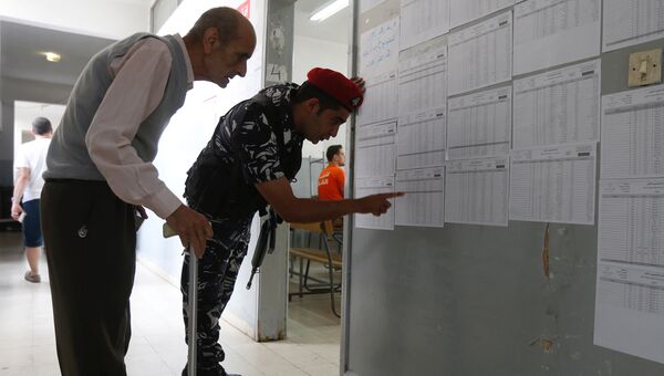 Мужчина изучает списки кандидатов на избирательном участке во время парламентских выборах в Бейруте, Ливан. 6 мая 2018