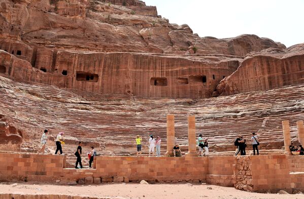 Туристы осматривают амфитеатр, построенный древними набатейцами, в городе Петра в Иордании
