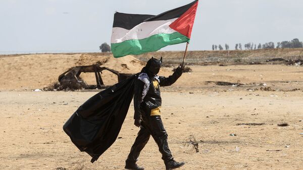Палестинский протестующий, одетый в костюм Бэтмена, на границе между сектором Газа и Израилем