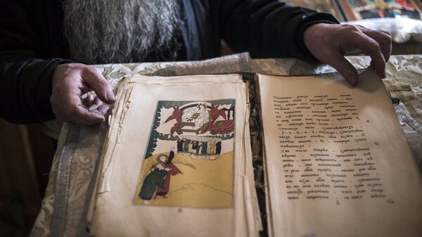 Священноиерей Сергий Попков (Палий) из семейского села Тарбагатай в Бурятии демонстрирует старинную религиозную книгу