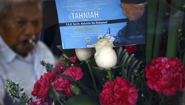 Букет цветов с поздравительной открыткой, на которой изображен новый премьер-министр Малайзии Махатхир Мохамад. Архивное фото