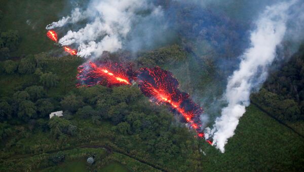 Лава извергается из трещины во время продолжающихся извержений вулкана Килауэа на Гавайях, США. 13 мая 2018