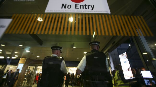 Сотрудники британской полиции у входа в терминал аэропорта в Лондоне. Архивное фото