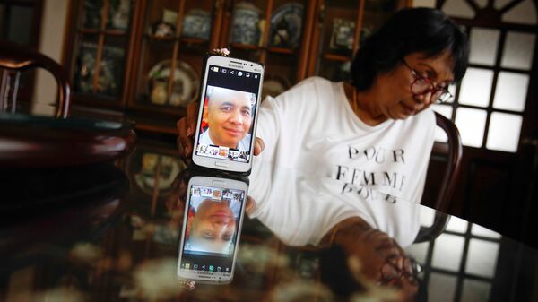 Портрет пилота пропавшего самолета Boeing 777-200 авиакомпании Malaysia Airlines Захарии Ахмада Шаха на экране телефона