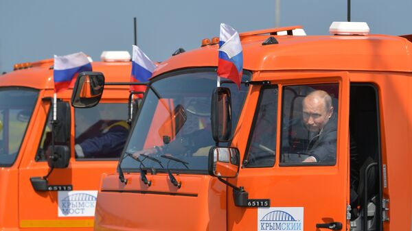 Президент РФ Владимир Путин садится за руль автомобиля Камаз во время проезда колонны строительной техники по автодорожной части Крымского моста. 15 мая 2018