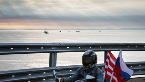 Мотоциклист едет по автодорожной части Крымского моста