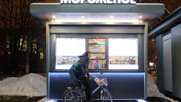 Велосипедист у киоска продажи мороженого на улице Москвы