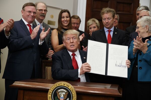 Президент США Дональд Трамп с подписанным указом, который сворачивает Obamacare, США. 12 октября 2017 Президент США Дональд Трамп с подписанным указом, который сворачивает Obamacare, США. 12 октября 2017