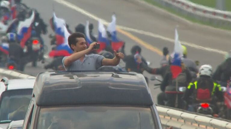 Путешественники приветствовали друг друга, впервые проезжая по Крымскому мосту Путешественники приветствовали друг друга, впервые проезжая по Крымскому мосту