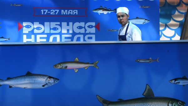 Торговец рыбой на площади Революции, где проходит Рыбная неделя в Москве. 17 мая 2018