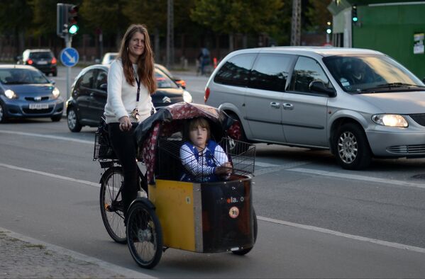 Девушка на велосипеде с ребенком на одной из улиц Копенгагена.