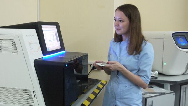 Научный сотрудник лаборатории ДНК-диагностики МГНЦ Ольга Миронович запускает секвенатор нового поколения
