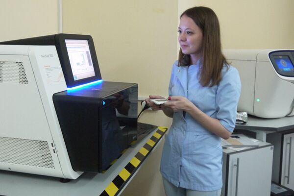 Научный сотрудник лаборатории ДНК-диагностики МГНЦ Ольга Миронович запускает секвенатор нового поколения