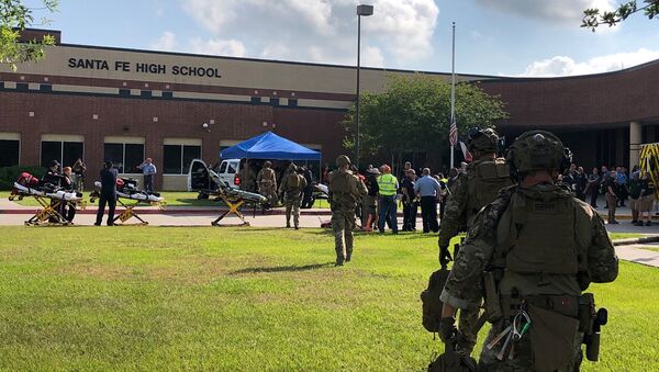 Сотрудники правоохранительных органов на месте стрельбы возле школы Санта-Фе Хай Скул в штате Техас, США. 18 мая 2018