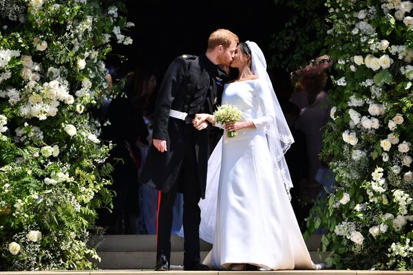 Британский принц Гарри и его жена Меган Маркл на выходе из церкви Святого Георгия в Виндзоре, Англия. 19 мая 2018