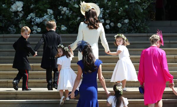 Кэтрин, герцогиня Кембриджская поднимается по ступеням с принцем Джорджем, принцессой Шарлоттой и подружками невесты на свадебную церемонию британского принца Гарри и актрисы Меган Маркл