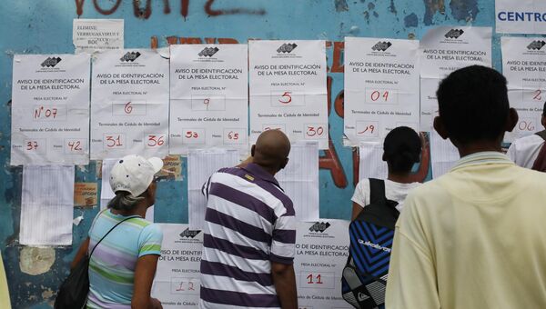 Венесуэльские граждане проверяют списки избирателей на избирательном участке во время президентских выборов в Каракасе, Венесуэла. 20 мая 2018