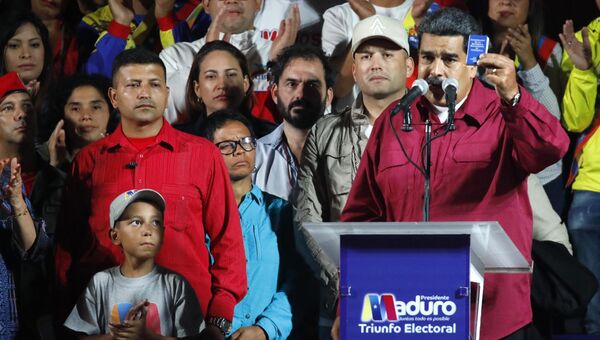 Президент Венесуэлы Николас Мадуро с копией Конституции страны выступает после обнародования результатов выборов. 20 мая 2018