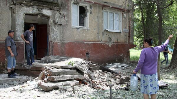 Жители во дворе жилого дома, пострадавшего в результате обстрела, в поселке Горловка Донецкой области. 21 мая 2018