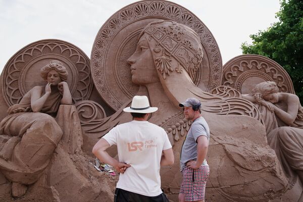 Мастер у скульптуры во время подготовки к открытию фестиваля песчаных скульптур в Санкт-Петербурге