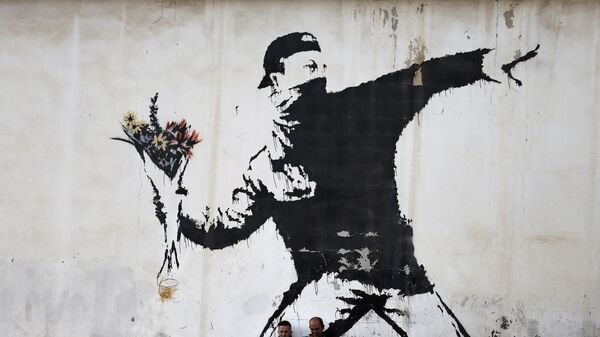 Граффити британского художника Бэнкси на стене заправочной станции в городе Вифлееме на Западном берегу реки Иордан. Архивное фотро