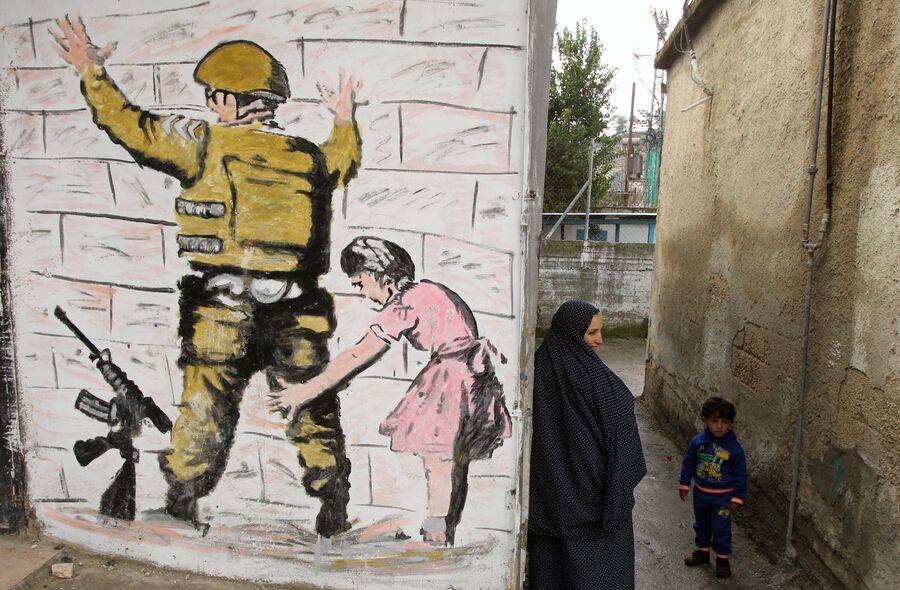 Граффити британского художника Бэнкси на стене в городе Вифлееме на Западном берегу реки Иордан