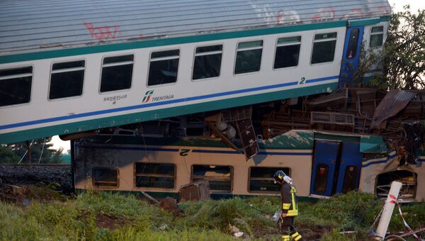 Пожарный на месте столкновения поезда и грузовика неподалеку от Турина в Италии