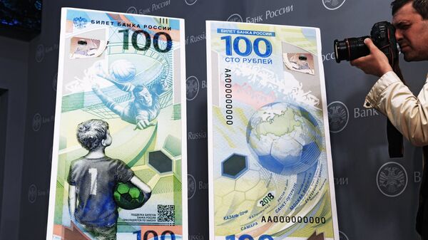 Фотограф фотографирует макет памятной банкноты Банка России, посвященной чемпионату мира по футболу FIFA 2018 года, на пресс-конференции в Москве