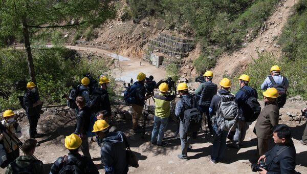 Иностранные журналисты неподалеку от шахты для ядерных испытаний №4 на ядерном полигоне Пхунгери на севере КНДР