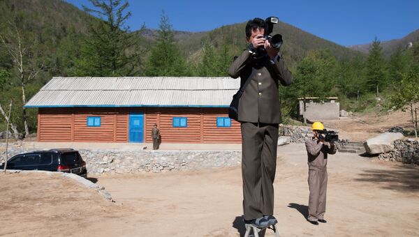 Журналисты из КНДР у здания управления шахтой для ядерных испытаний №2 на ядерном полигоне Пхунгери на севере КНДР