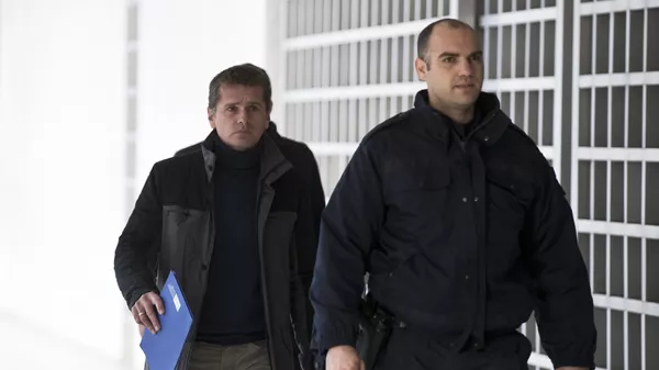 Полицейский сопровождает Александра Винника в Верховный суд Греции в Афинах. Архивное фото