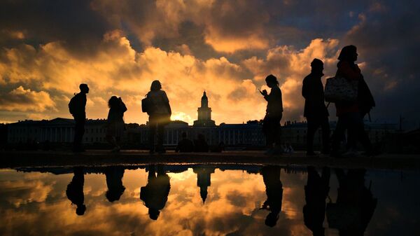 Горожане гуляют на Адмиралтейской набережной Санкт-Петербурга