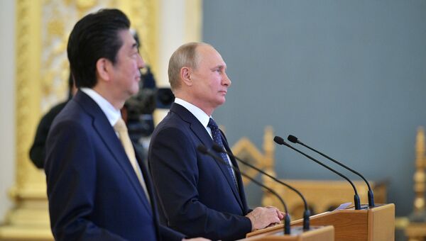 Президент РФ Владимир Путин и премьер-министр Японии Синдзо Абэ во время сеанса связи с экипажем МКС в рамках встречи в Кремле. 26 мая 2018