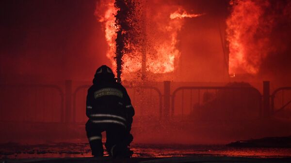 Сотрудник пожарной службы МЧС России во время тушения пожара. Архивное фото