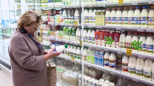 Покупатель у витрины с молочной продукцией